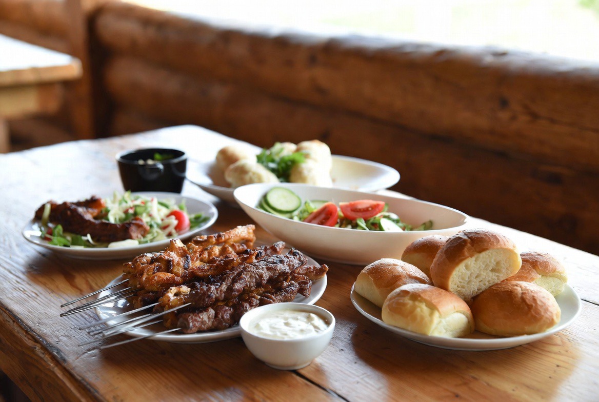 Traditional Bulgarian mehana meal with grilled meats, salad and bread showing cost of living in Bulgaria 2026